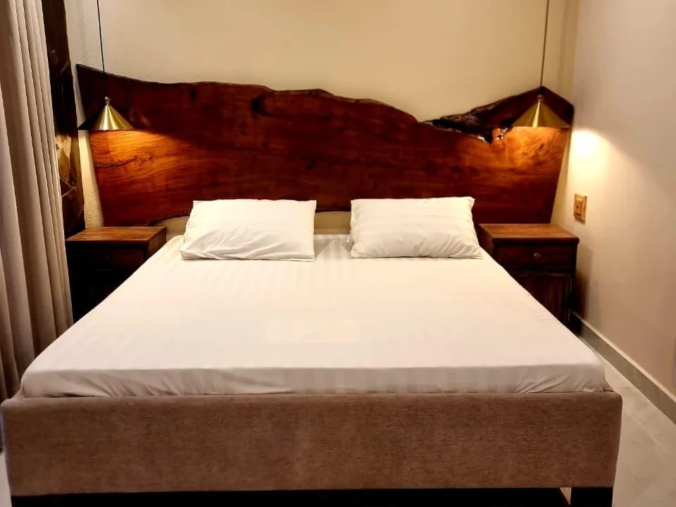 Modern apartment bedroom with live-edge wooden headboard at Serenity Hilltop Homes